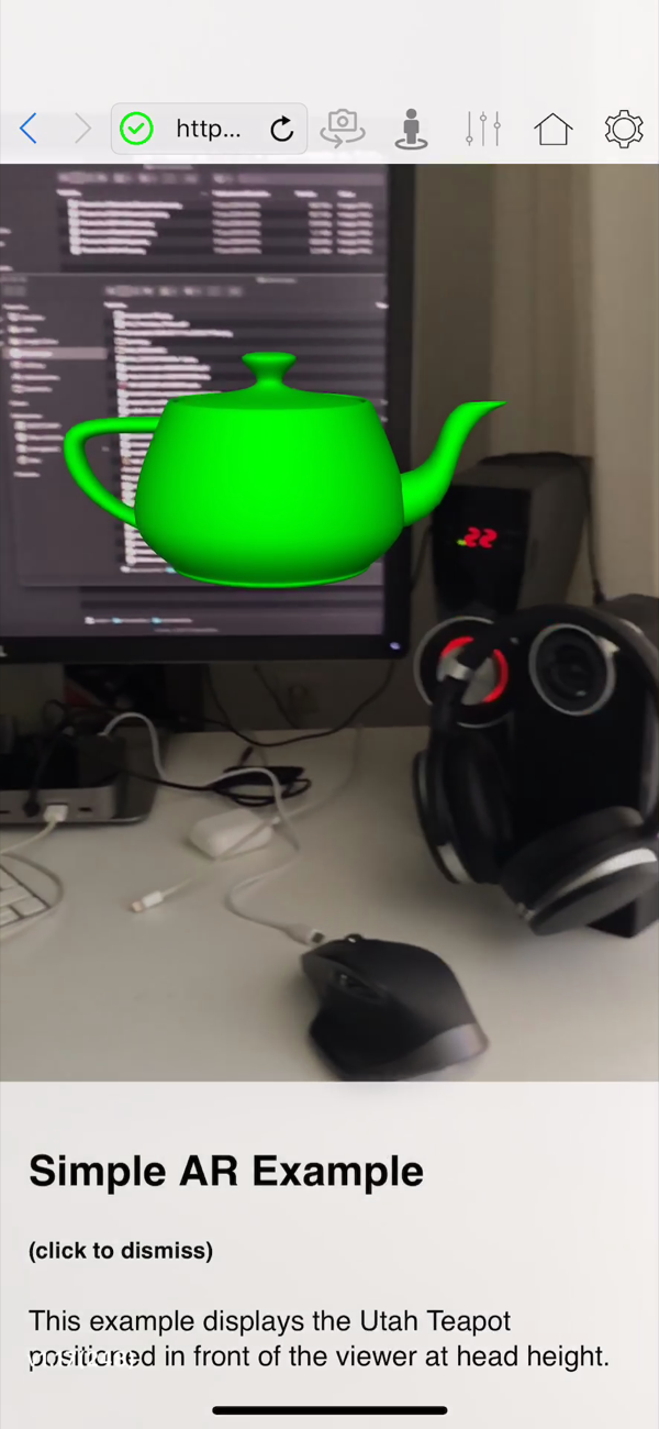 The WebXR Viewer placing a green 3D teapot in front of a desk monitor